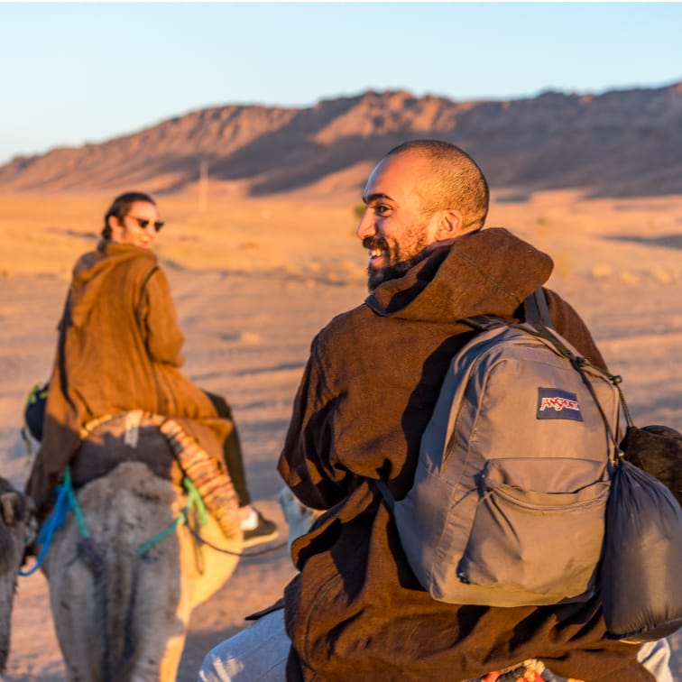 Rhys and Tim riding camels in the Sahara